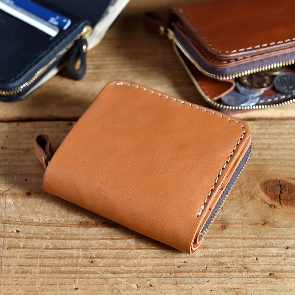 ワンアクションで小銭にアクセスできるコンパクトな二つ折り財布 / 革