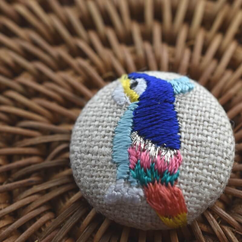 カラフル羽毛の鳥[青いオウム_parrot]刺繍のくるみボタン・ピン | mimi