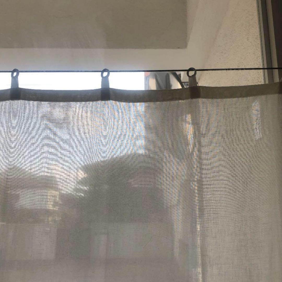 古い白磁リングがついた生成りのカーテン